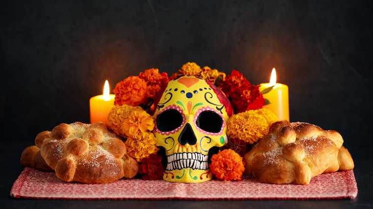 A traditional Día de los Muertos ofrenda with Day of the Dead food, marigolds, and candles displayed.